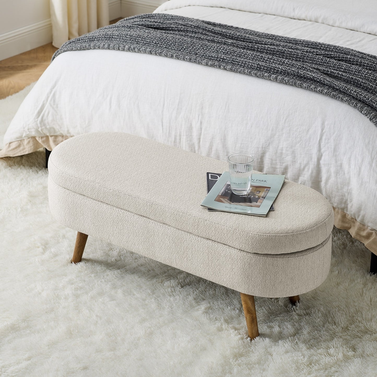 An elegant oval ottoman with hidden storage, crafted for timeless function and refined style