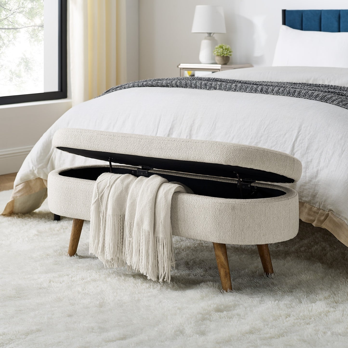 An elegant oval ottoman with hidden storage, crafted for timeless function and refined style
